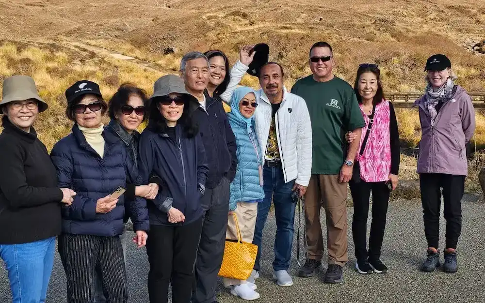 From the Autumn Tour in 2024, a group of tourists stop for a photo beneath Aso